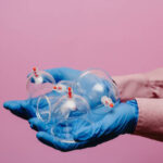 Vacuum pumps and jars for hijama. Arms. On a pink background