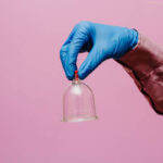 Vacuum pumps and jars for hijama. Arms. On a pink background