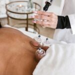 A woman receiving cupping therapy in a serene spa setting to relieve pain and stress.